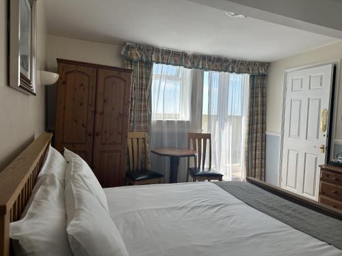a bedroom with a white bed and a window at The Lindum in Hastings