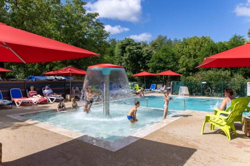 a group of people playing in a swimming pool at Camping la Plage Lot Vallée de la Dordogne Rocamadour in Meyronne