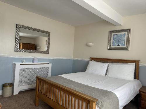 a bedroom with a large bed with a mirror at The Lindum in Hastings