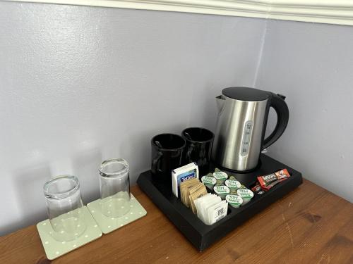a tray with a coffee maker and glasses on a table at The Lindum in Hastings