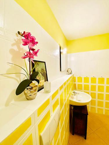 a bathroom with a sink and a vase with flowers on a counter at Waldschenke Stendenitz Übernachten im Wald am See in Neuruppin