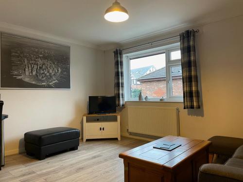 a living room with a couch and a table and a window at The Mews in the heart of Stockton Heath in Warrington