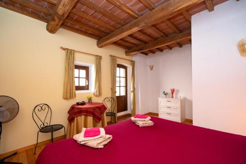 a bedroom with a red bed and a table at Podere Vecci in Dicomano
