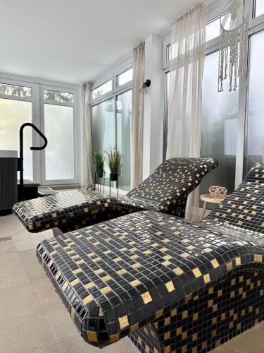 two beds in a room with windows at Al-Dom Apartamenty, SUN w Welle z dostępem do sauny i jacuzzi in Grzybowo