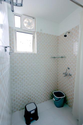 a bathroom with a toilet and a window and a sink at Supremo Home Stays in Agra