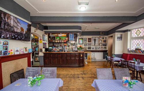 a dining room with two tables and a bar at The Stag and Hen Pub in Coventry