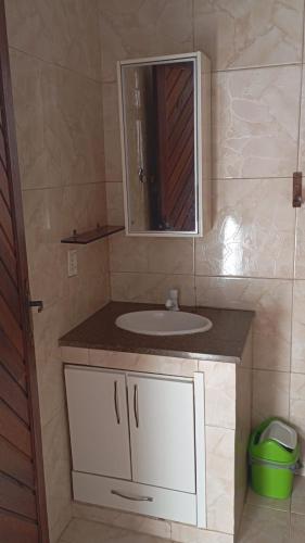 a bathroom with a sink and a mirror at J U N Q U E I R A i in Mangaratiba