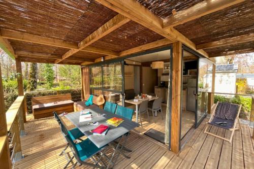 a patio with a table and chairs on a deck at Camping le Relais du Léman in Messery
