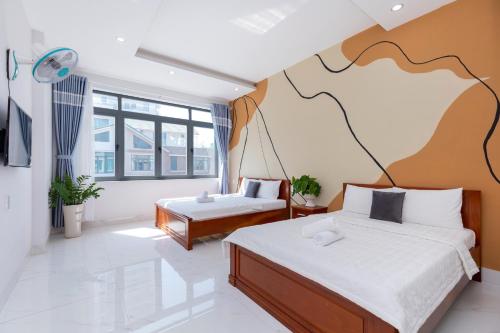 a bedroom with two beds and a large mural on the wall at B2-11 Hoàng My Villa in Vung Tau