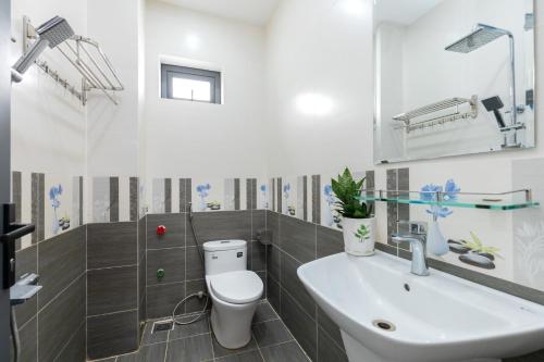 a bathroom with a white toilet and a sink at B2-11 Hoàng My Villa in Vung Tau