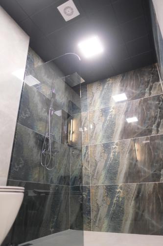 a bathroom with a shower with a stone wall at 1921 justa sefa otel in Amasya
