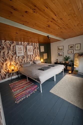 a bedroom with a bed and a wooden ceiling at Duplex dans le centre d'Heusy in Verviers