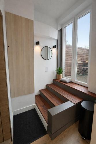 a room with stairs with a mirror and a window at Duplex dans le centre d'Heusy in Verviers