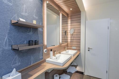 ein Badezimmer mit Waschbecken und Spiegel in der Unterkunft Hotel Wehrburg in Cuxhaven