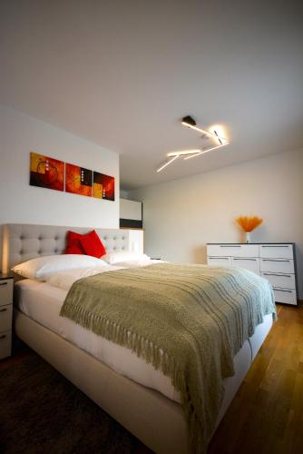 a bedroom with a large white bed and a ceiling at Ferienwohnungen Neubauer in Kaltenberg