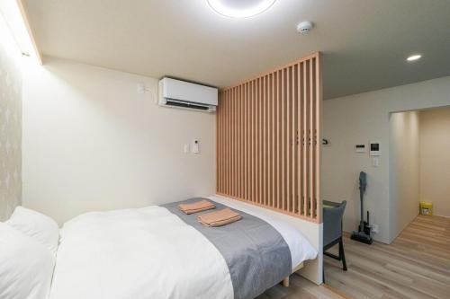 a bedroom with a large bed with a wooden headboard at Seed INN Haneda Terrace 203 in Tokyo
