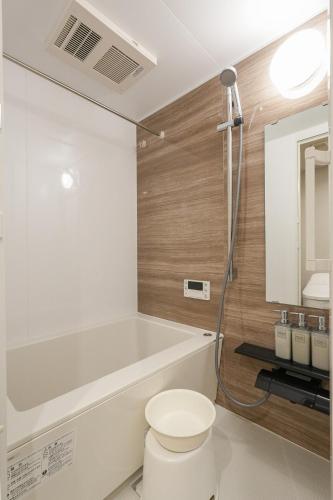 a bathroom with a toilet and a sink and a mirror at Seed INN Haneda Terrace 203 in Tokyo
