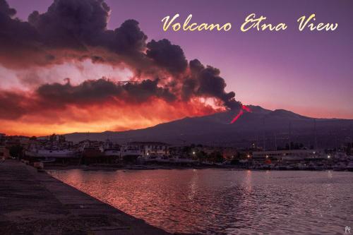 a fire in the sky over a body of water at Le Ville della Contea -Vacation rentals in Mascali
