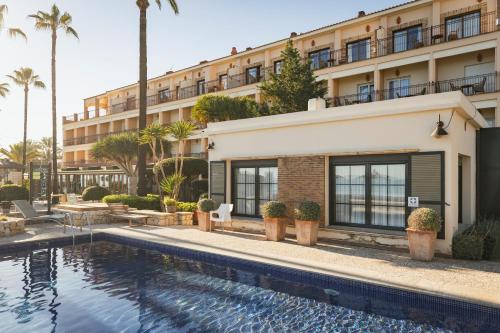 a hotel with a swimming pool in front of a building at Hotel Los Ángeles Denia in Denia
