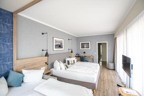 ein Hotelzimmer mit zwei Betten und einem Fernseher in der Unterkunft Hotel Wehrburg in Cuxhaven