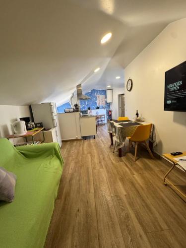 a living room with a green couch and a table at House in the Heart of Funchal with big balcony in Funchal