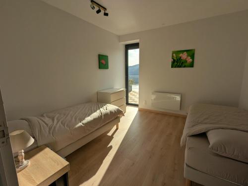 a bedroom with two beds and a window at Gîte du Vieux Cuvage in Vaux-en-Beaujolais