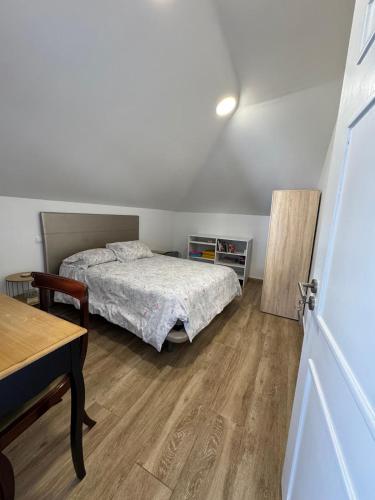 a bedroom with a bed and a table in it at House in the Heart of Funchal with big balcony in Funchal