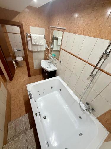 a bathroom with a large white tub and a sink at Kornilios Istron Hotel in Giannitsa