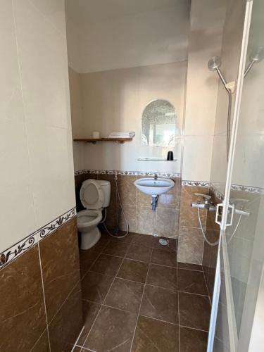 a bathroom with a toilet and a sink and a shower at Thái Lâm Hotel in Da Lat