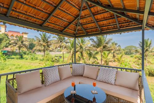a porch with a couch and a table at Casa Mandala by ELIVAAS in Candolim