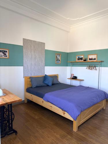 a bedroom with a large bed with blue sheets at Thái Lâm Hotel in Da Lat