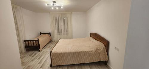 a small bedroom with a bed and a chair at Harmony house in Bakuriani