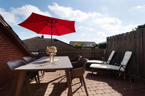 a table with a red umbrella on a patio at Instenweg 14 Sternhus in Rettin