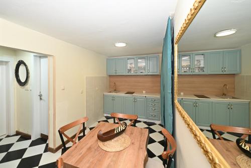 a kitchen with a table and chairs and blue cabinets at Two bedroom Vintage apartment in Kotor
