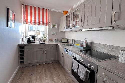 a kitchen with white cabinets and a sink at Wohnung 9 in Westerland