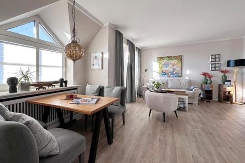a living room with a table and a dining room at Wohnung 9 in Westerland