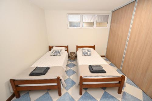 two beds in a small room with a window at Two bedroom Vintage apartment in Kotor