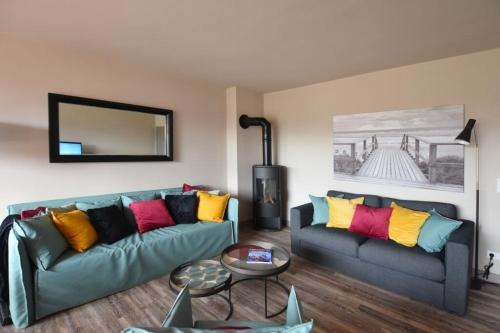 a living room with two couches with colorful pillows at Ferienhaus Barke 17 in Tinnum