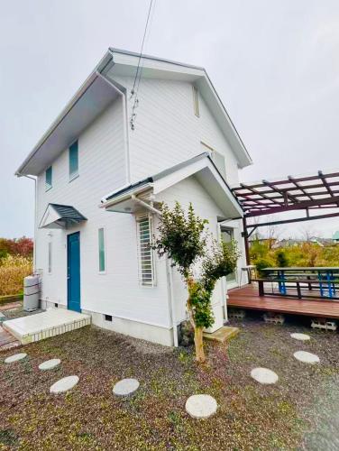 a white house with a bench in front of it at Biwa Takashima BBQ可 近湖周道路 in Takashima