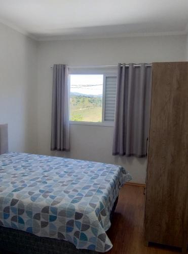 a bedroom with a bed and a window at Casa aconchego in Socorro