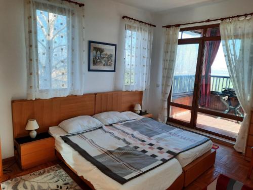 a bedroom with a bed and a large window at Villa Jasmin in Aheloy