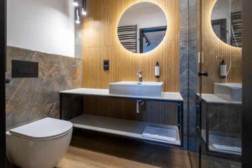 a bathroom with a sink and a toilet and a mirror at Apartamenty Beski in Szczyrk