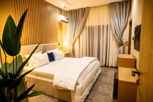 a hotel room with a bed and a potted plant at EXQUISITE Home 2 Abuja in Abuja