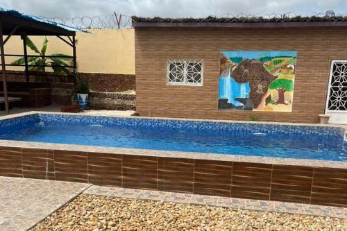 a large swimming pool next to a building with a painting at Sendou Cabano Villa Sleeps 6 with Parking in Siendou