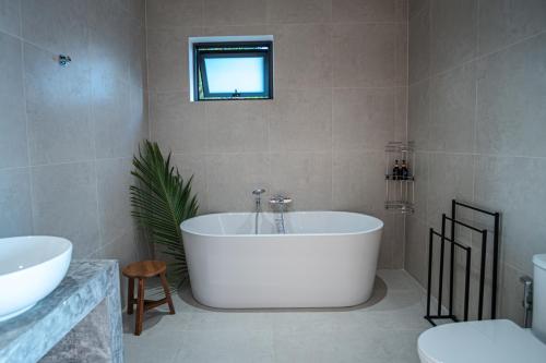 a bathroom with a large white tub and a window at InnSpire Villa - Breathtaking Sunset View in Hinkong