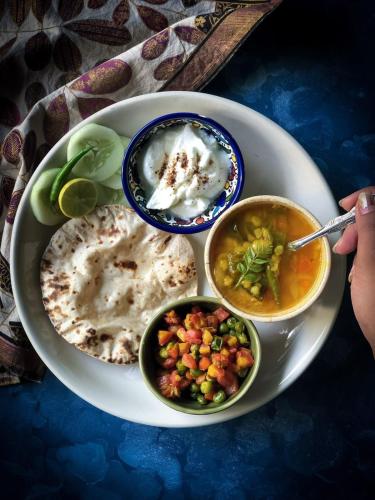 a plate of food with bowls of food on a table at Hotel Casa Square in Indore