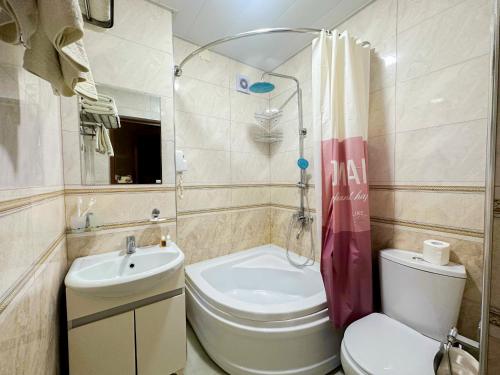 a small bathroom with a toilet and a sink at Gold Camel Registan in Samarkand