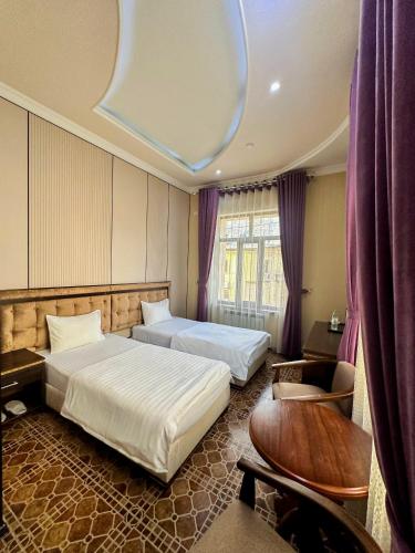 a hotel room with two beds and a chair at Gold Camel Registan in Samarkand