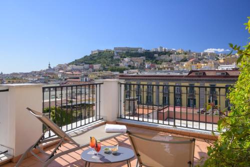 a balcony with a table and chairs on a roof at Hotel Piazza Bellini & Apartments in Naples