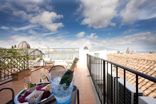 a table with a bottle of wine on a balcony at Hotel Piazza Bellini & Apartments in Naples
